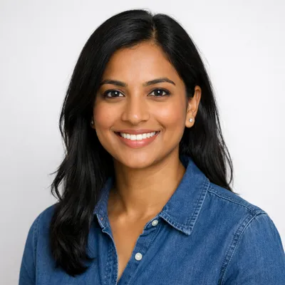 Professional headshot of a diverse adult with a warm expression on a light background.